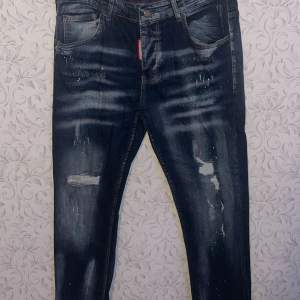 Säljer ett par snygga blå jeans från Dsquared2 i regular fit. (Storlek 52) De har en cool slitning och färgstänk som ger en unik look. Perfekta för både vardag och fest! Om du har mer frågor skriv privat ! MVH Viggo