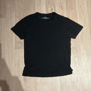 Svart t-shirt  - Säljer en klassisk svart t-shirt . Den har en v-ringad hals och är kortärmad, perfekt för vardagsbruk eller som basplagg. Materialet känns mjukt och bekvämt, troligen bomull. Passar till alla tillfällen och är lätt att matcha med andra kläder. 🖤