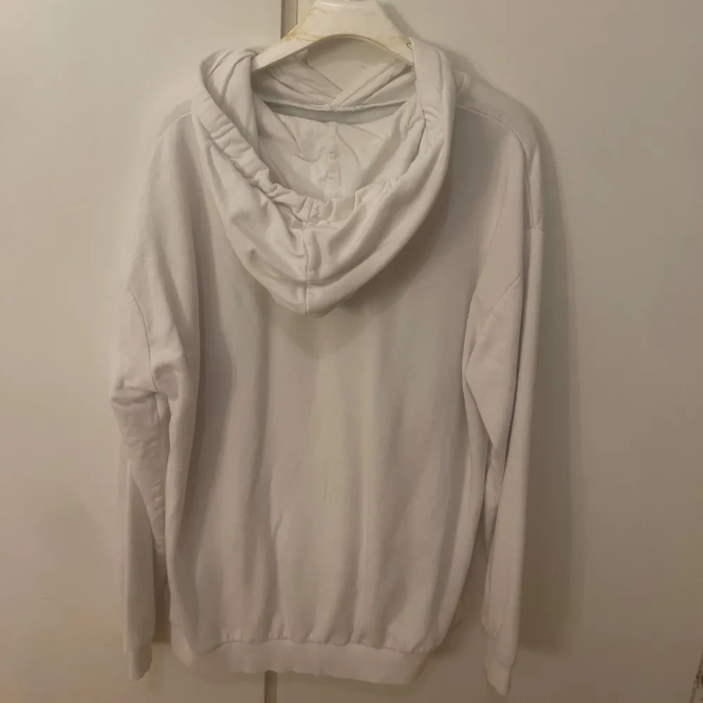 En vit oversized hoodie i bra skick, den är i storlek M så den sitter oversized på mig som brukar ha S så skulle säga att den passar en S-M 🤍. Hupparit & Collegepaidat.