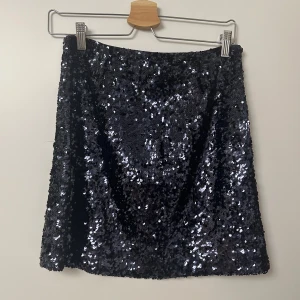 Svart paljettkjol - Snygg mörkblå paljettkjol som glittrar. Perfekt för festliga tillfällen. Kjolen är kort och köpt från Cubus. Perfekt för nyår eller en utekväll med vänner. Tryck gärna på köp nu🩷🥂 Aldrig använd
