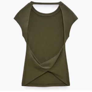 Olivgrön backless topp - Snygg olivgrön backless topp med korta ärmar. Den är perfekt för sommardagar eller en avslappnad utekväll. Toppen är i ett mjukt och stretchigt material som ger en bekväm passform och man känner inte dig strypt runt halsen