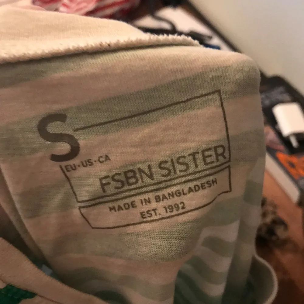 Säljer en snygg grön- och vitrandig t-shirt från FSBN Sister i storlek S. Den är croppad och har en avslappnad passform, perfekt för sommardagar. Tillverkad i ett mjukt och bekvämt material. Perfekt för en casual look! 🌿. T-shirts.