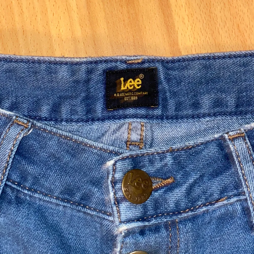 Säljer ett par snygga blå jeans från Lee i mycket bra skick. Modellen är wide leg. Jeansen har knappar framtill och är perfekta för både vardag och fest!. Jeans & Byxor.