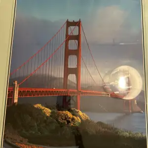 Snygg poster med motiv av Golden Gate Bridge i San Francisco. Den har en vacker vy över bron med dimma i bakgrunden och texten 'San Francisco' längst ner. Perfekt för att ge rummet en touch av Kalifornien-känsla!