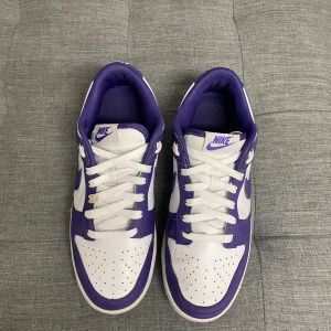 Nike Dunk Court purple - Säljer ett par Nike Dunk court purple. Skorna är i mycket bra skick förutom att ett skosnöre är lite smutsigt. Skorna är storlek 41 men passar 42.