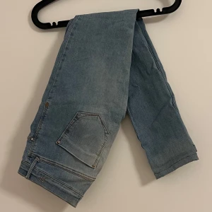 Blå jeans från River Island - Snygga blå jeans från River Island med slitna detaljer på benen. Perfekta för en avslappnad stil. De har en klassisk femficksdesign och är tillverkade i ett bekvämt denimtyg.