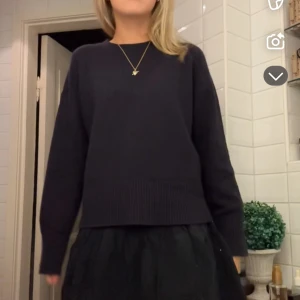 Mörkblå stickad tröja - mörkblå stickad tröja med ribbade kanter.