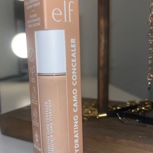 e.l.f. Hydrating Camo Concealer - e.l.f. Hydrating Camo Concealer i nyansen 'Light Peach'. Denna concealer erbjuder full täckning med en satin finish och har en stor applikator för enkel applicering. Produkten är vegansk och cruelty-free. Helt ny och inte använd!
