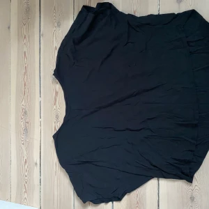 Svart topp från H&M - Säljer en svart tshirt från H&M! Kortare där fram och längre bak!