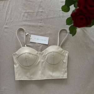 Vit korsett från Amisu - Snygg beige/vit korsett från Amisu med justerbara axelband och dragkedja bak. Perfekt för en stilren look. Den har en elegant design med formade kupor. Storlek M men passar S också ❣️