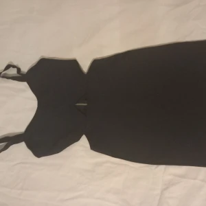 Svart axelbandslös klänning - Elegant svart klänning med axelbandslös design och en smickrande passform. Perfekt för en kväll ute eller en speciell tillställning.