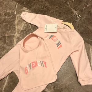 Givenchy baby set - Givenchy baby set med jumpsuit och haklapp. Ny med prislapp. Storlek 9 manader. Köpt för ca 3400kr.