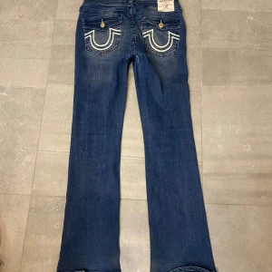 True religion ”becca” jeans bootcut Midwaist - Fick hem dom men dom var pågränsen till för små på mig, därav säljs dom!! •Storlek 30 ~Midja: 40cm ~Innerben: 79 cm •Bootcut och Midwaist •Defekt mellan benen där det har skavts av en del färg (dock inget som syns så mycket när man har på sig dom). ~Grenhöjd: 25 cm ~bredd längst ned vid fotens ända:23 cm