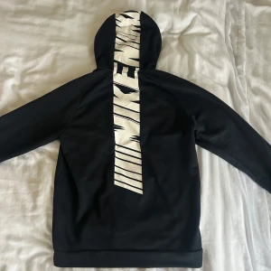 NIKE TRACK SUIT - Svart hoodie med dragkedja och vit Nike-logga på bröstet. Matchande svarta byxor med vit logga på benet. 