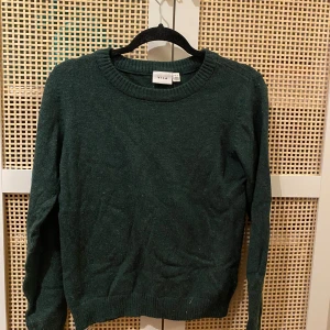 En mörk grön stickad tröja - En mörk grön stickad tröja i storlek XS och är ifrån vila. Tröjan är skrynklig i bilden för att den har varit vikt i min garderob ganska länge