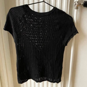 Svart topp från Zara - Snygg svart ”stickad” topp från Zara med korta ärmar och ett dekorativt mönster framtill och baktill. Perfekt  som statement-plagg och för fest, eller till ett par jeans 🩷Kan mötas upp i Sthlm, annars står köparen för frakten