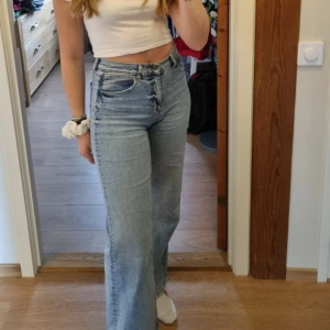 Ljusa jeansbyxor från Ideal Pants - Ljusa jeansbyxor från Ideal Pants med en wide fit. De har en klassisk femficksdesign och hög midja. Tyvärr står inte storleken på byxorna men skulle säga att det är S.