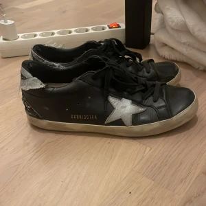 Svarta Golden Goose  - Säljer mina svarta Golden goose då de har blivit för små. Väl använt skick med några mindre defekter (se bild). Nypris ca 6 000kr. 