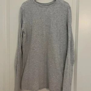 Grå långärmad tröja från H&M - Säljer en enkel grå långärmad tröja från H&M. Perfekt för vardagsbruk med en bekväm passform. Tillverkad i mjukt material för extra komfort. 