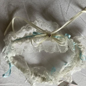 Vitt strumpeband m blått i  och  brudslöja - Elegant vitt strumpeband nytt med spetsdetaljer och en lång slöja. Perfekt för ditt bröllop. Strumpebandet ( nytt)  har en fin rosett och små pärlor som ger en extra touch av elegans.