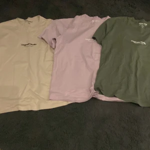 T-shirt från Jack & Jones i tre färger - Säljer tre snygga t-shirts från Jack & Jones Originals i färgerna beige, lila och grön. De har en enkel design med texten 'Original Studio' tryckt på framsidan. Perfekta för en avslappnad stil.