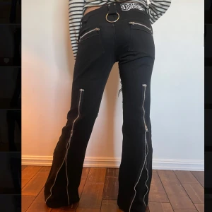 Bootcut jeans med dragkedjor - Snygga svarta byxor med flera dragkedjor och detaljer. Byxorna har bootcut och är 92 i innerbenslängd. 31/34