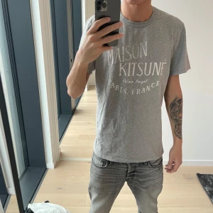 Maison Kitsune T-shirt - Grå maison Kitsune T shirt, storlek L fits M. Jag är 187 och väger ungefär 65kg. Tröjan är i bra skick.