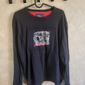 Svart långärmad tröja från Peak Performance - Säljer en svart långärmad tröja från Peak Performance med ett tryck på framsidan. Tröjan har en rund halsringning och är perfekt för en avslappnad stil. Passar bra till både jeans och chinos.