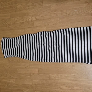 Randig långklänning - Snygg långklänning med svartvita ränder och en slits baktill. Aldrig använd då den inte passade mig.