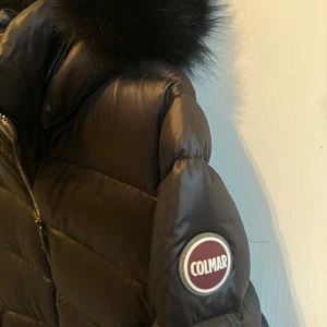 Dunjacka från Colmar - Colmar Semi-Glossy Down Jacket med Hood, svart, storlek S   Säljer en Colmar-jacka i storlek S, i svart med äkta päls på huvan. Jackan är i utmärkt skick, knappt använd, och ser ut som ny. Nypris: 5620 kr. Originalkvitto finns och den är köpt hos Minto.
