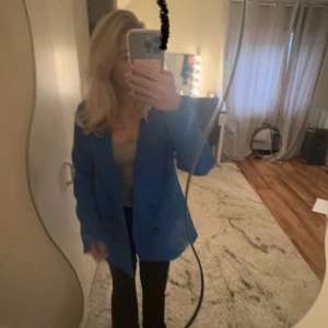 Blå kavaj från My Essential Wardrobe - Snygg blå kavaj från My Essential Wardrobe i modellen MMyola Blazer. Kavajen har en klassisk design med knappar framtill och är perfekt för en stilren look. Färgen är Victoria Blue och den passar utmärkt för både vardag och speciella tillfällen. Original priset på denna fina kavaj/kappa är 1800 säljer den för 650kr eftersom ingen användning helt ny med prislapp men priset kan alltid diskuteras ❤️