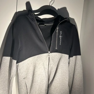 Grå och svart huvtröja från Sail Racing - Snygg huvtröja från Sail Racing i grått och svart. Diskuterar mer info i DM!!!!