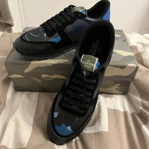 Blåa rockrunners - Snygga! Rockrunners med ett coolt kamouflagemönster i svart och blått. Skorna har snörning och en stilren design som passar perfekt för vintern. Skorna är storlek 45 men passar 44 och 43. Meddela vid funderingar!