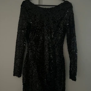 Svart paljettklänning från NLY One - Snygg svart klänning från NLY One i storlek XS. Klänningen är täckt med glittrande paljetter och har en elegant öppen rygg. Den är långärmad och perfekt för en festlig kväll. Har tyvärr aldrig kommit till användning då den är för liten. Hör av er vid frågor💕