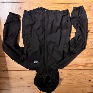 Svart vindjacka från The North Face - Säljer en svart vindjacka från The North Face med huva och dragkedja. 