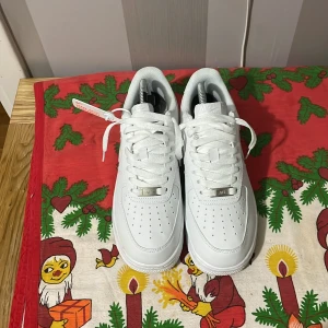 Vita Nike Air Force sneakers - Snygga vita Nike Air Force sneakers med klassisk design och snörning. Perfekta för en stilren look. Skorna har en robust sula och är tillverkade i skinn.