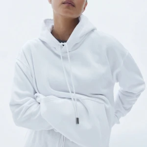 Huvtröja med slits - Vit huvtröja med slits. En lång hoodie med en stor ficka i mitten. Pris kan diskuteras