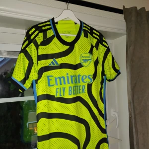 Arsenal borta matchtröja - Arsenal borta matchtröja utan tryck på ryggen Från förra säsongen  Aldrig använd, lappen finns kvar på tröjan som man kan se på bilden. Köpt från adidas Vid mer frågor eller bilder skriv gärna ps finns på fler sidor