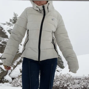 Vit pufferjacka från super dry - Säljer en snygg vit pufferjacka med huva och dragkedja från super dry! Jacksn är i fint skick och Andvänd en skidsäsong!🤍🤍(lite smink fläckar vid kragen)