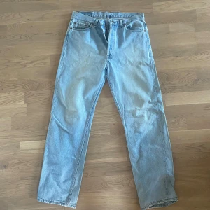 Ljusblå vintage Levis 501 jeans stl 36x32 - Säljer ett par klassiska ljusblå Levis 501 jeans. De har en rak passform och är tillverkade i slitstarkt denim. Perfekta för en avslappnad stil. Passar både till sneakers och boots.