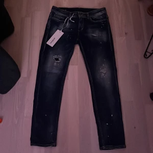 Dondup Monroe Skinny Jeans - Snygga Dondup Monroe skinny jeans i mörkblå denim med slitna detaljer och en modern skinny fit. Tillverkade i Italien, dessa jeans har en klassisk femficksdesign och en stilren look! Köpta för 3,5k i affär! Topp skick använda endast Max 6 gånger! Obs inget og.