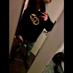 Svart tröja från Kenzo med gulddetaljer - Snygg svart tröja från Kenzo med ett stort guldfärgat tryck på framsidan. Tröjan har en klassisk passform och är perfekt för en stilren look. Den är långärmad och har ribbade muddar vid ärmslut och nederkant. Nypris på denna tröjan är 3400kr! Mitt pris : 1500kr!🍾Dm för frågor eller funderingar . Mvh Kian🍾🔥