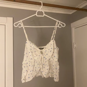 Vit topp - Vit topp med blommigt mönster från bik bok i storlek XS
