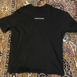 Svart t-shirt med grafiskt tryck - Snygg svart t-shirt från Sweet Skateboards med ett unikt grafiskt tryck på baksidan i flera färger. Framsidan har en enkel logotyp i vitt. Perfekt för en avslappnad stil.