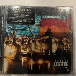 Metallica S&M CD - Dubbel-CD med Metallica och San Francisco Symphony Orchestra, dirigerad av Michael Kamen. Innehåller 20 låtar inklusive klassiker som 'Enter Sandman' och 'Master of Puppets'.