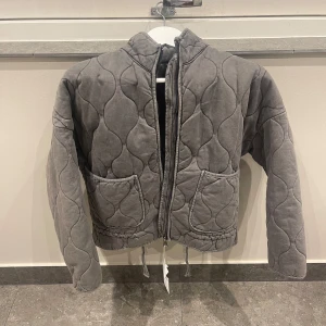Grå quiltad jacka - Säljer en snygg grå quiltad jacka med dragkedja och två stora fickor framtill. Oanvänd, mycket bra skick. Kontakta vid frågor!💕