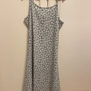 Blommig klänning från 157 New - Söt blommig klänning från 157 New med smala axelband och ett avslappnat fall. Perfekt för varma dagar med sitt lätta och luftiga material.