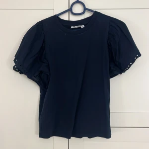 Mörkblå topp från Kappahl - Säljer en mörkblå topp från Kappahl med korta puffärmar. Strl Xs