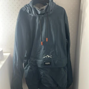 Dope skidjacka - Snygg blå jacka från Dope med huva och dragkedja. Jackan har en stor ficka framtill och ett coolt märke på ärmen. En perfekt jacka för dig som gillar att åka skidor/vara ute mycket. Storleken på jackan är S  och den är använd 4-5 gånger. Nypris 1100 kr!