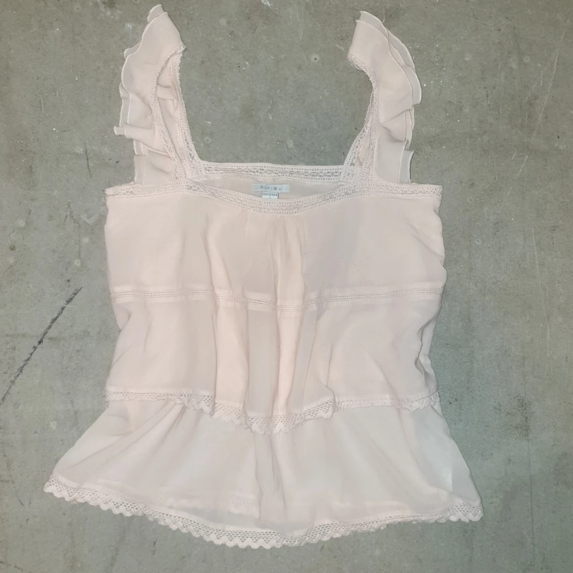 Puderrosa topp med spetsdetaljer